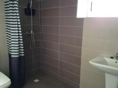 a bathroom with a shower and a toilet and a sink at Palm Grove Farm in Tit Mellil