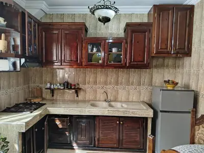 a kitchen with wooden cabinets and a sink and a refrigerator at appartement a casablanca in Casablanca