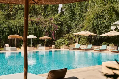 a swimming pool with lounge chairs and umbrellas at Hyatt Regency Casablanca in Casablanca