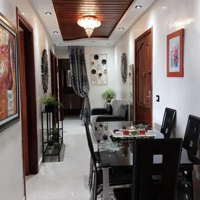 a living room with a table and a couch at Appartement avec terrasse au cœur du centre-ville de Rabat in Rabat
