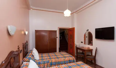 a bedroom with a bed and a table and a tv at Hôtel Astrid in Casablanca