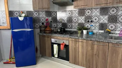 a kitchen with a blue refrigerator and a sink at Joli appartement Casablanca ain sebaa in Casablanca
