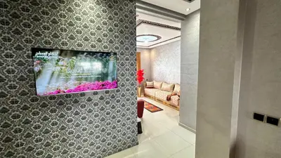 a living room with a tv on a wall at Joli appartement Casablanca ain sebaa in Casablanca