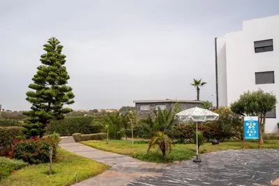 a walkway in front of a building with a tree at Garden Bay Appart'Hôtel in Casablanca