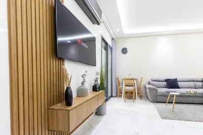 a living room with a flat screen tv on a wall at Miramar Residence Beach in Mohammedia