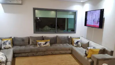 a living room with a couch and a flat screen tv at Champs Elysee in Casablanca