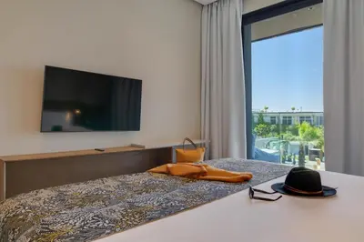 a hotel room with a bed with a hat and glasses at Pestana Casablanca, Seaside Suites & Residences in Casablanca