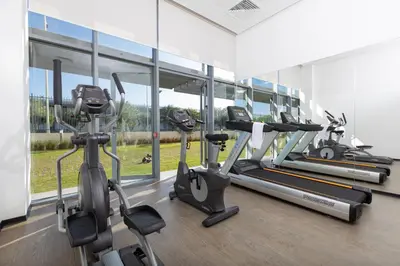 a gym with several treadmills and elliptical machines at ONOMO Airport Casablanca in Casablanca