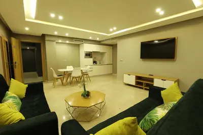 a living room with a couch and a flat screen tv at Mid Town Hotel Casablanca in Casablanca