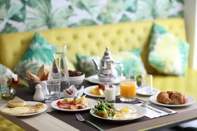 a table topped with plates of breakfast foods and orange juice at Mid Town Hotel Casablanca in Casablanca