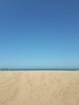 a sandy beach with the ocean in the background at Appartement Miramar in Mohammedia