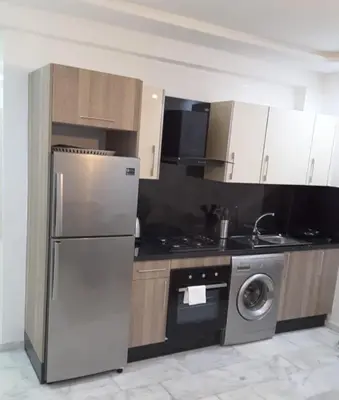 a kitchen with a stainless steel refrigerator and a dishwasher at Appartement Miramar in Mohammedia