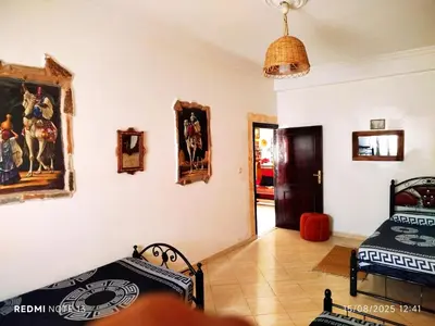 a room with two beds and paintings on the wall at Appartement a casablanca in Casablanca