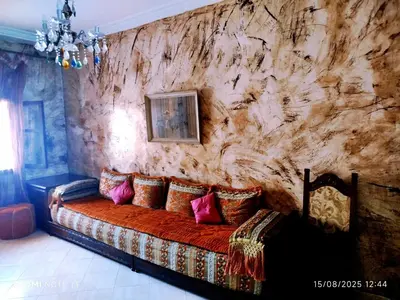 a living room with a couch against a stone wall at Appartement a casablanca in Casablanca