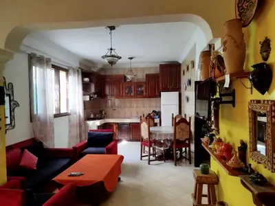a living room with a table and a kitchen at Appartement a casablanca in Casablanca