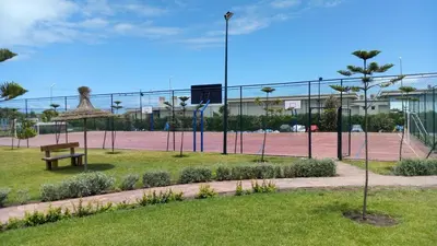 a tennis court with a bench on a tennis court at Dar Lazraq in Sidi Rahal