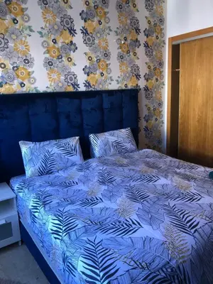 a bed in a bedroom with a blue comforter at Hadil Room in Rabat