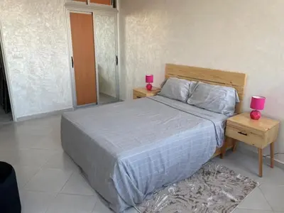 a bedroom with a large bed with two pink candles at Melines in Casablanca