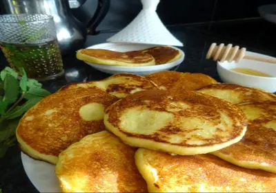 a pile of pancakes on a plate on a table at Charmant Appartement avec une vue imprenable in Tamaris