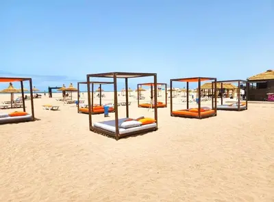 a row of beds on a sandy beach at CASA BAY BEACH RETREAT in Sidi Rahal