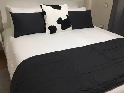 a black and white bed with black and white pillows at Appartement près de Novotel face au parc WELCOME STAY in Mohammedia