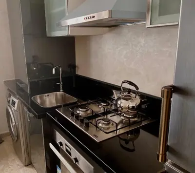 a kitchen with a stove top and a sink at Appartement près de Novotel face au parc WELCOME STAY in Mohammedia