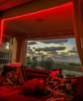 a living room with a large window with red lights at Sea View Luxury Apartment Just Steps from the beach in Bouznika