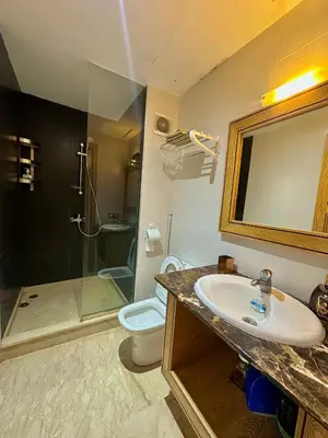 a bathroom with a sink and a shower and a toilet at Sea View Luxury Apartment Just Steps from the beach in Bouznika