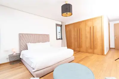 a white bedroom with a bed and a table at KEEP CALM AND THINK OF THE SEA, MARINA!! in Casablanca