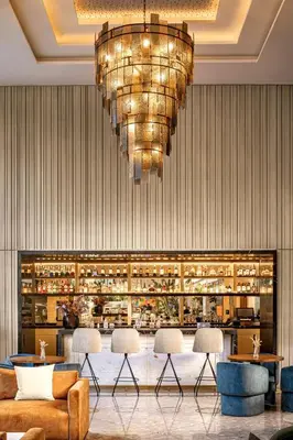 a lobby with a bar with a chandelier at Radisson Blu Hotel Casablanca City Center in Casablanca