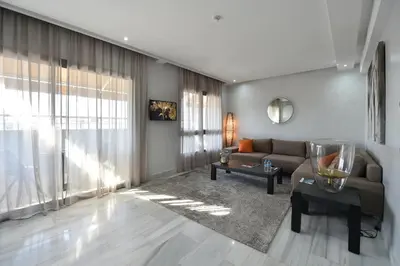 a living room with a couch and a table at Le Yacht Suites Hotel in Casablanca