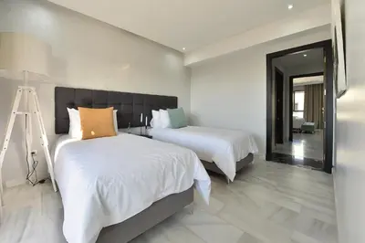 a bedroom with two beds and a mirror at Le Yacht Suites Hotel in Casablanca