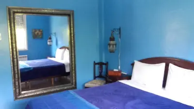 a blue bedroom with a mirror and a bed at Riad TANJIL in Casablanca