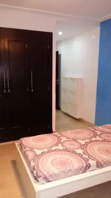 a bedroom with a bed and a black cabinet at Appartement de luxe in Casablanca