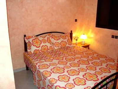 a bedroom with a bed with a floral bedspread at Silia Appartements in Temara