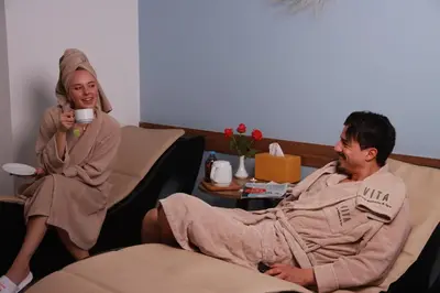 a woman sitting next to a man in a robe at New Hotel Piscine Wellness & Spa in Casablanca