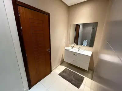 a bathroom with a sink and a wooden door at BEST unit NEAR Casablanca AIRPORT in Casablanca