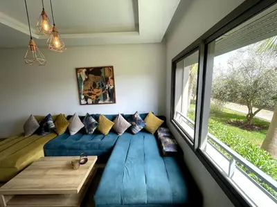 a living room with a blue couch and a window at BEST unit NEAR Casablanca AIRPORT in Casablanca