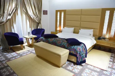 a bedroom with a king sized bed and a couch at Aralia Boutique Hôtel in Rabat