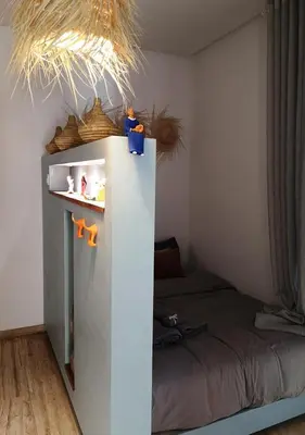 a small bedroom with a bed and a white wall at LAU 09 Studio Terrasse in Rabat