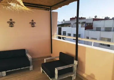 a balcony with a couch and a chair on a building at LAU 09 Studio Terrasse in Rabat