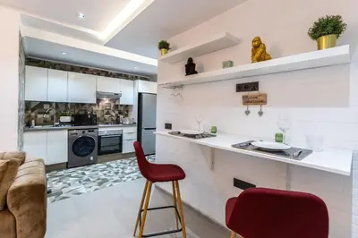 a kitchen with a counter and a red chair at Stylish & Chic Flat - Best Place - New Building in Casablanca