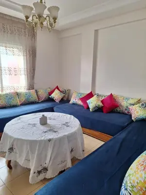 a living room with a blue couch with a table at ocean view apartment in Rabat