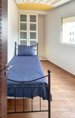 a bedroom with a bed with blue sheets and a window at Spacious apartment in Nouaseur of 167 m² in Nouaseur