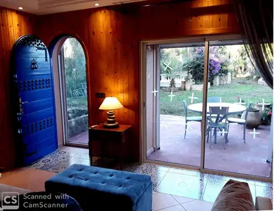 a living room with sliding glass doors and a table at Palmeraie skhirat1 in Skhirat