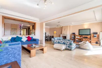 a living room with blue couches and a tv at Residence Elite appartement de luxe in Casablanca