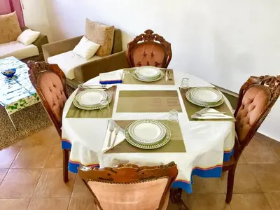 a dining room table with plates on it with a couch at Elegant villa in Dar Bouazza with year-round private pool in Dar Bouazza