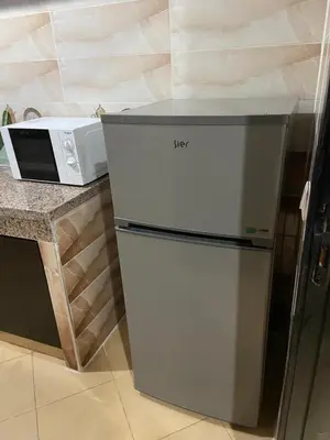 a refrigerator in a kitchen next to a microwave at Mohammed V International Airport HOUSE in Nouaseur
