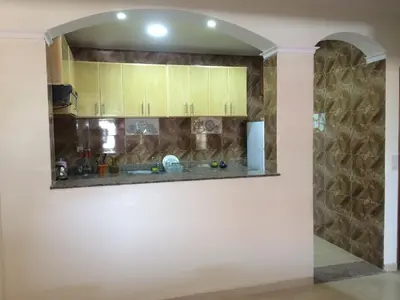 a kitchen with yellow cabinets and a stone wall at Home Sweet Home Just a 2-Minute Walk to the Tram