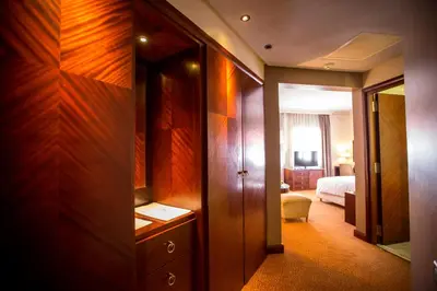 a hotel room with a closet and a bedroom at Hotel Atlantic Agdal in Rabat